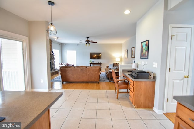 living area featuring a ceiling fan, recessed lighting, a fireplace, light tile patterned floors, and baseboards