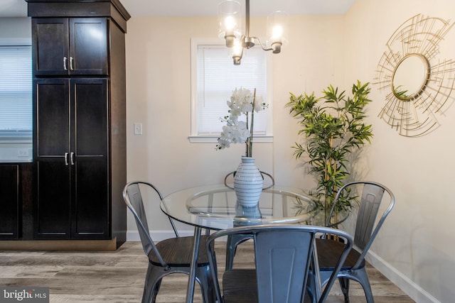 dining space featuring light hardwood / wood-style floors and a notable chandelier