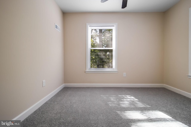 empty room featuring ceiling fan and carpet