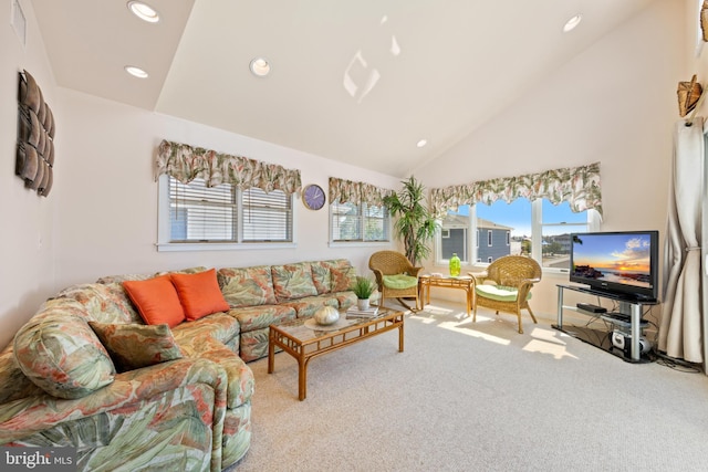 carpeted living room with high vaulted ceiling