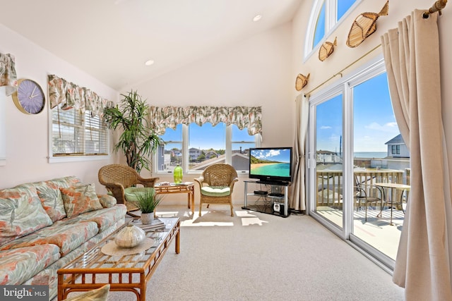 living room with carpet flooring, vaulted ceiling, and a wealth of natural light