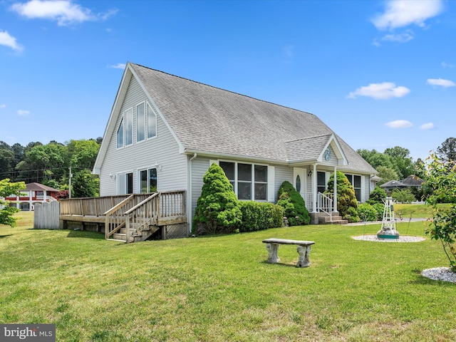 rear view of house featuring a storage shed, a wooden deck, and a yard