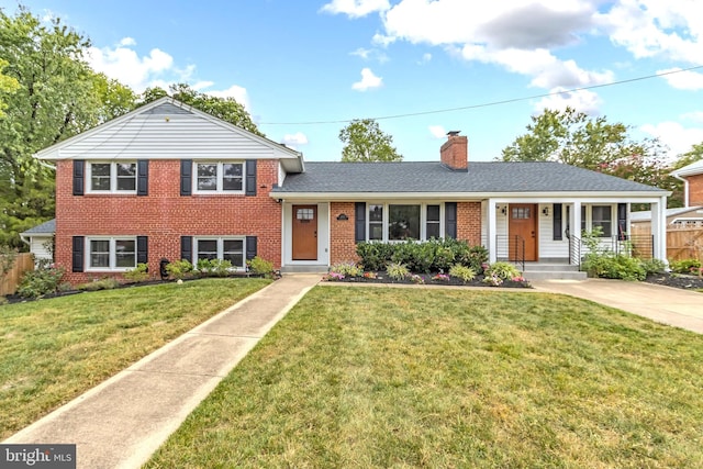 tri-level home featuring a front lawn and covered porch