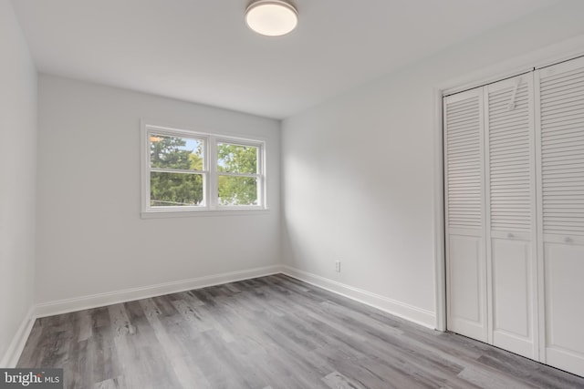 unfurnished bedroom featuring light hardwood / wood-style flooring and a closet