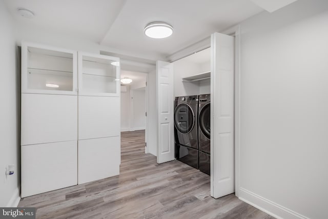 washroom featuring light hardwood / wood-style floors and washing machine and clothes dryer