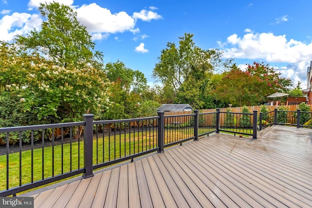 wooden terrace featuring a lawn