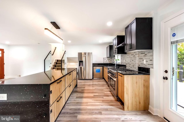 kitchen with light brown cabinets, sink, tasteful backsplash, stainless steel appliances, and light hardwood / wood-style floors