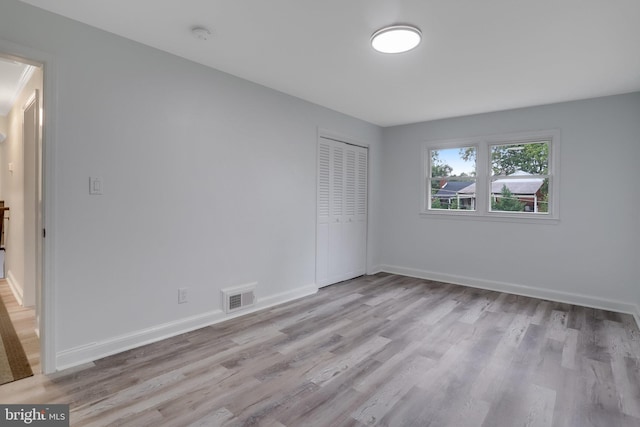 unfurnished bedroom featuring light hardwood / wood-style flooring and a closet