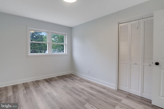 unfurnished bedroom with a closet and light hardwood / wood-style floors