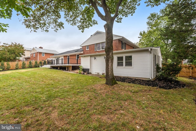 rear view of property featuring a wooden deck and a yard