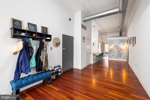 mudroom featuring dark hardwood / wood-style flooring and a towering ceiling