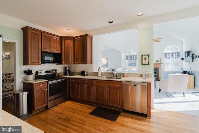 kitchen with stainless steel appliances, light hardwood / wood-style flooring, plenty of natural light, and sink