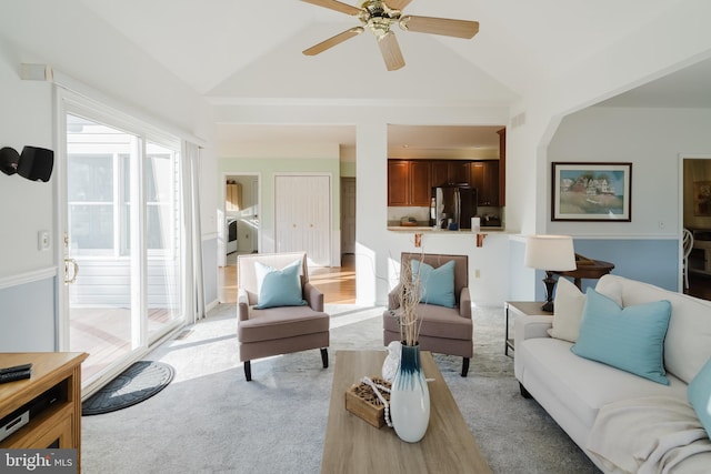 carpeted living room with ceiling fan and lofted ceiling