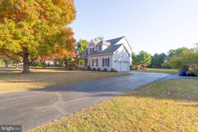 cape cod house with a garage and a front lawn