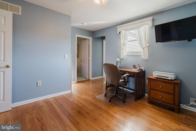 home office with light wood-type flooring and ceiling fan