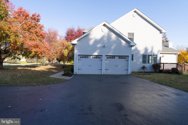 view of property exterior featuring a yard and a garage