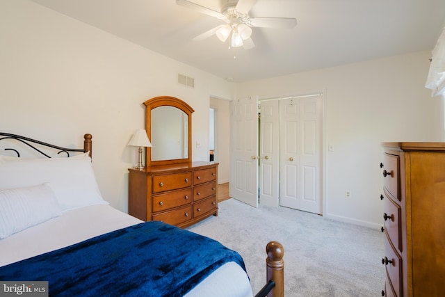 carpeted bedroom with ceiling fan and a closet