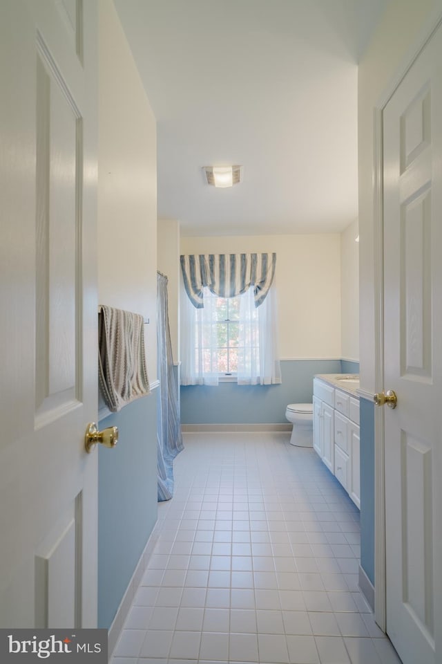 bathroom featuring tile patterned flooring, vanity, and toilet