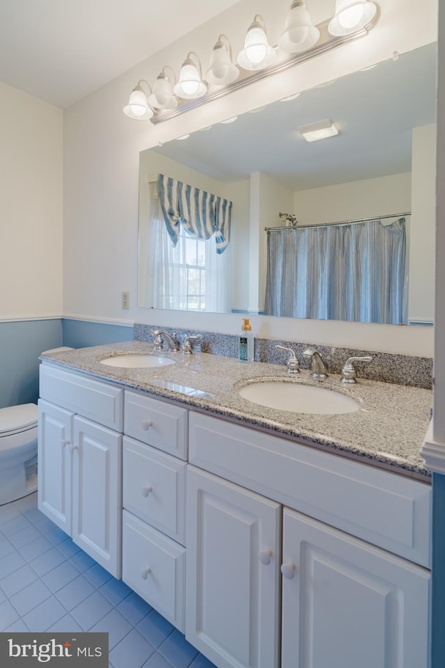 bathroom featuring tile patterned floors, walk in shower, vanity, and toilet