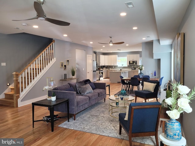 living room with light hardwood / wood-style floors and ceiling fan