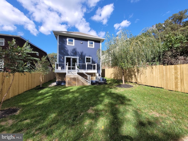 rear view of property with a wooden deck and a yard