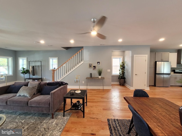 living room with light hardwood / wood-style floors, plenty of natural light, and ceiling fan