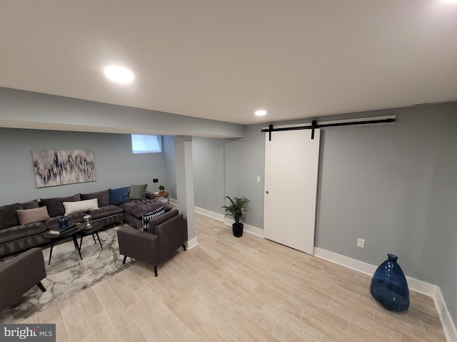 living room featuring a barn door and light wood-type flooring