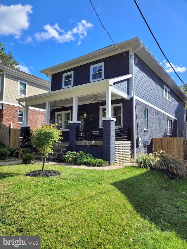 view of front facade with ceiling fan and a front lawn