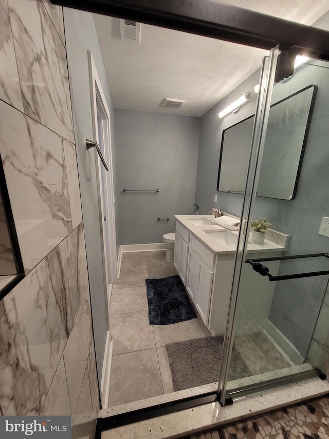 bathroom with vanity, toilet, tile patterned floors, and an enclosed shower