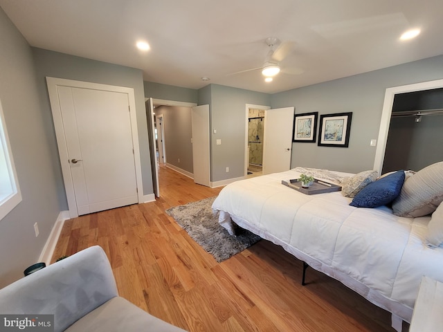 bedroom featuring a closet, connected bathroom, light hardwood / wood-style floors, and ceiling fan