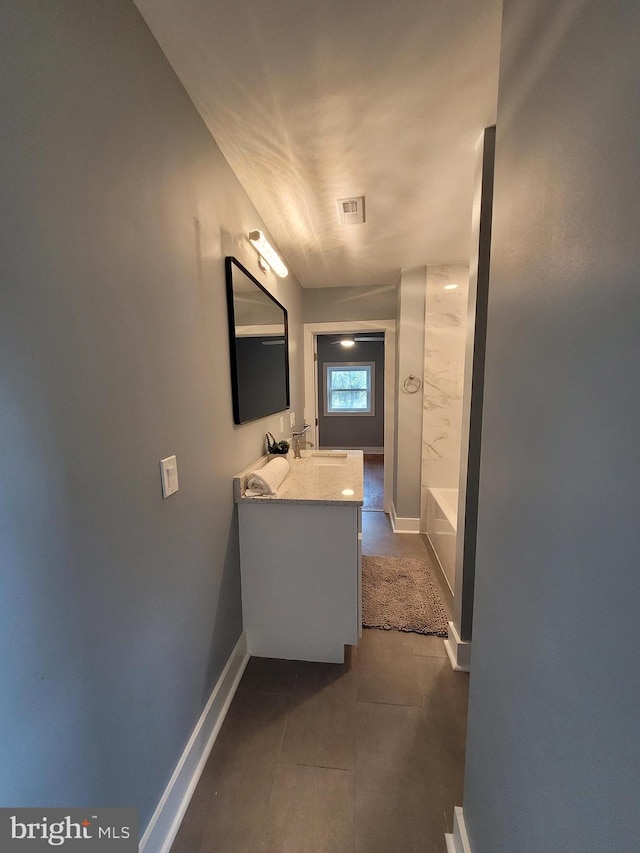 bathroom with a bath, tile patterned flooring, and vanity