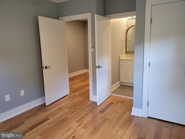 unfurnished bedroom with sink and light hardwood / wood-style floors