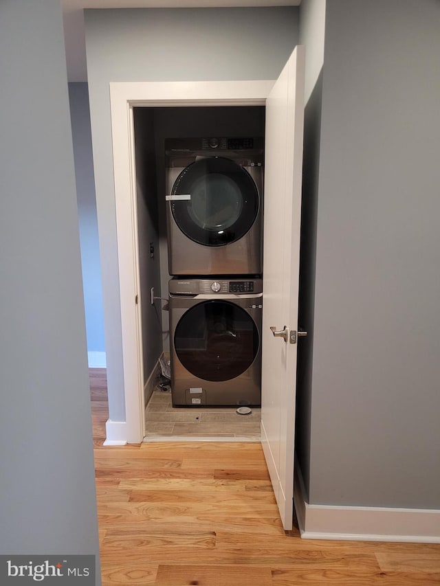 washroom featuring light wood-type flooring and stacked washer and clothes dryer