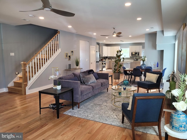 living room with light wood-type flooring and ceiling fan