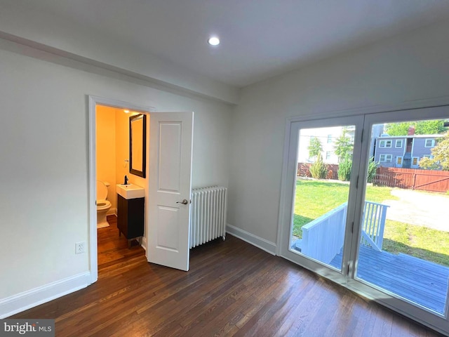 interior space with dark hardwood / wood-style floors and radiator