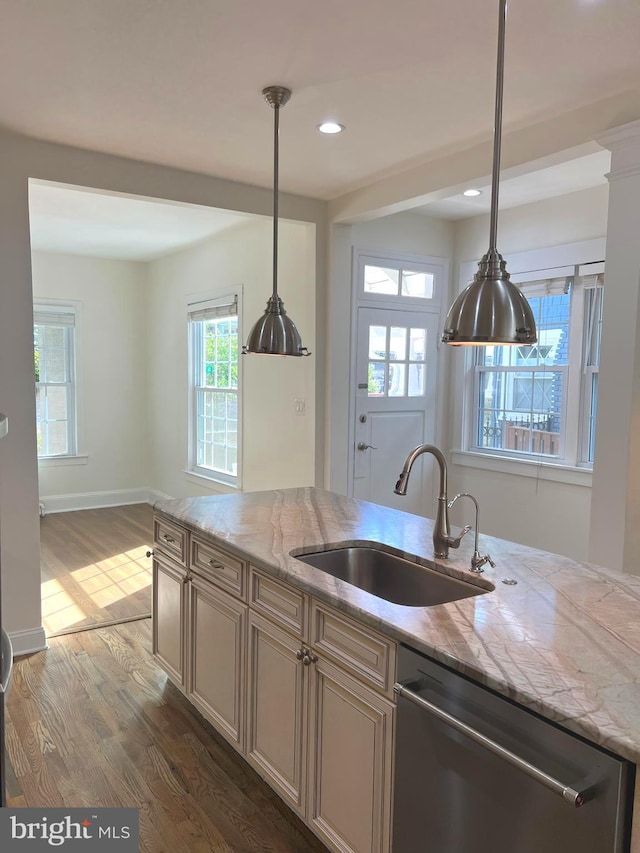 kitchen with light stone counters, stainless steel dishwasher, dark hardwood / wood-style floors, and sink