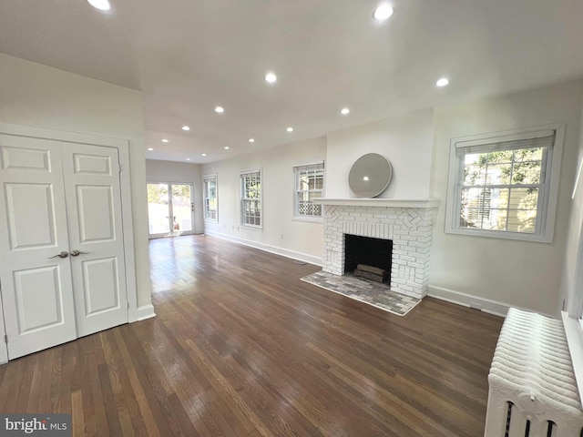 unfurnished living room featuring dark wood-type flooring and a fireplace