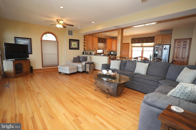 living room with ceiling fan and light hardwood / wood-style flooring