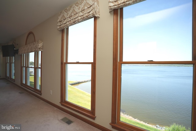 interior space with a water view and carpet flooring