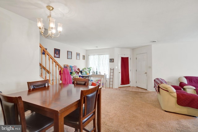 dining area featuring an inviting chandelier and light colored carpet