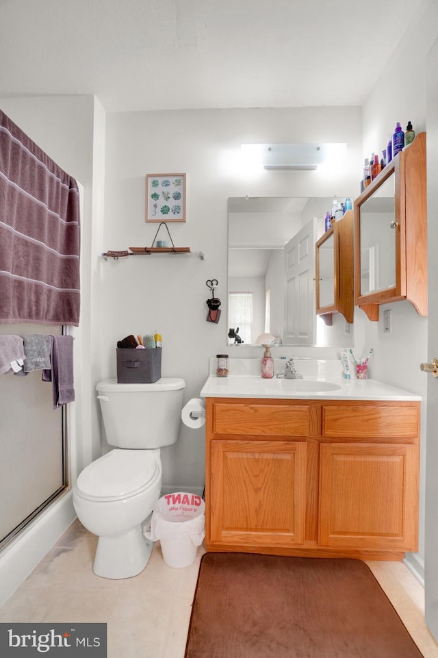 bathroom featuring vanity, toilet, an enclosed shower, and tile patterned floors