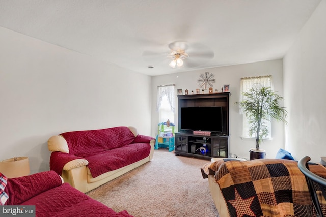 living room with ceiling fan and carpet