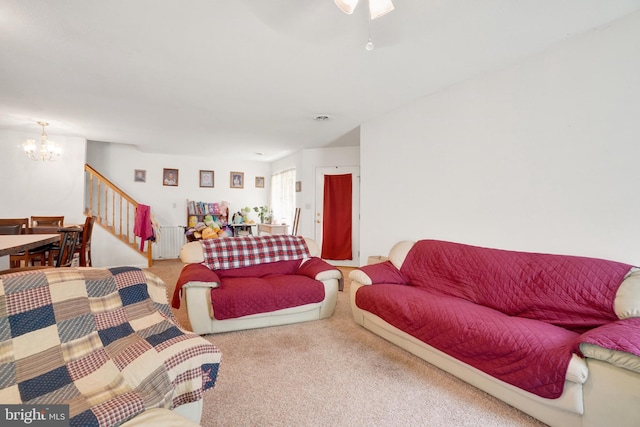 living room featuring ceiling fan with notable chandelier and carpet flooring