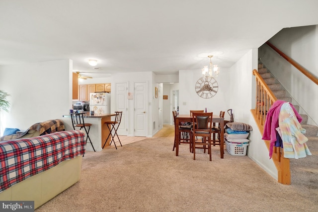 dining room with light carpet and ceiling fan with notable chandelier