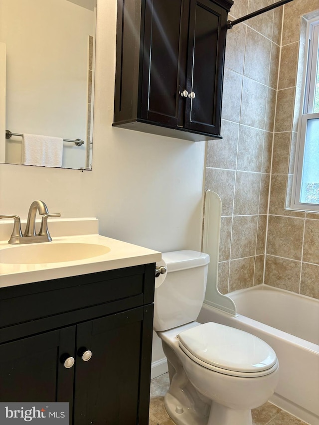 full bathroom featuring tiled shower / bath, vanity, toilet, and tile patterned floors