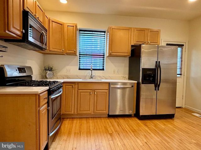 kitchen featuring light wood-type flooring, sink, and stainless steel appliances