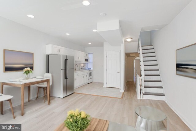 living room with light hardwood / wood-style flooring and sink