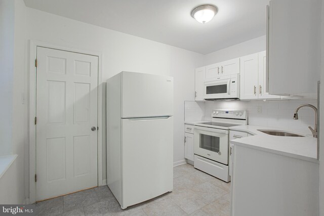 kitchen featuring white cabinetry, white appliances, backsplash, light tile patterned floors, and sink