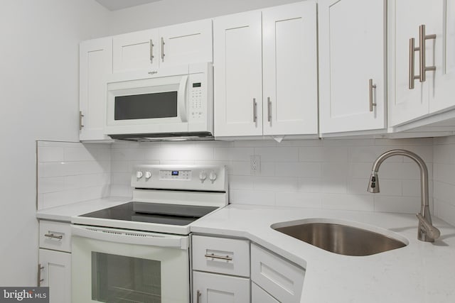 kitchen featuring sink, white appliances, and white cabinets