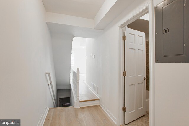 hall with electric panel and light hardwood / wood-style flooring